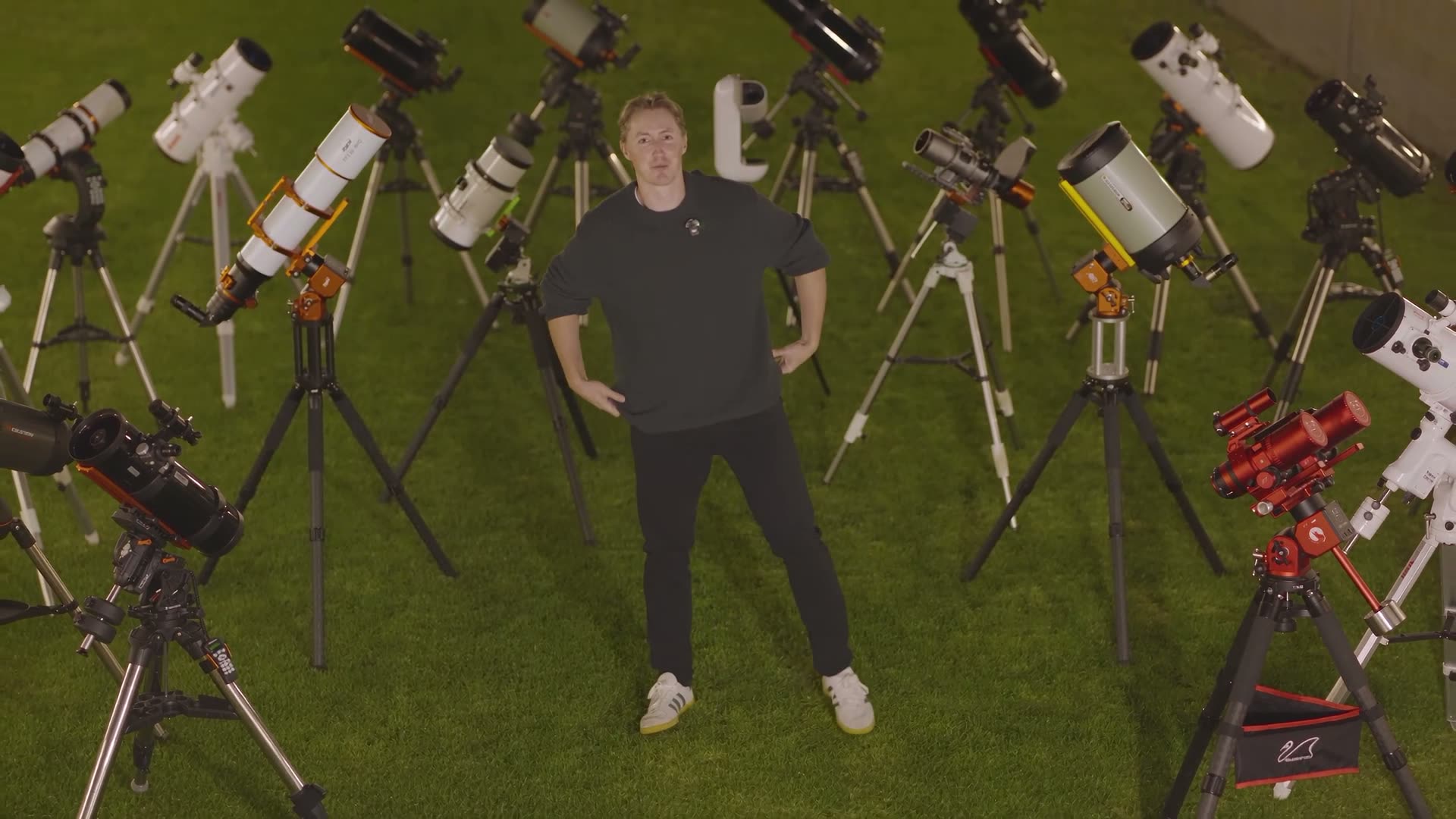 Damon Scotting seen from above, surrounded by dozens of telescopes on the lawn